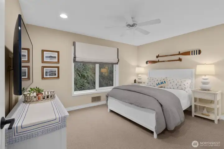 The second en-suite bedroom overlooks the lush hillside, offering a serene retreat for relaxation.