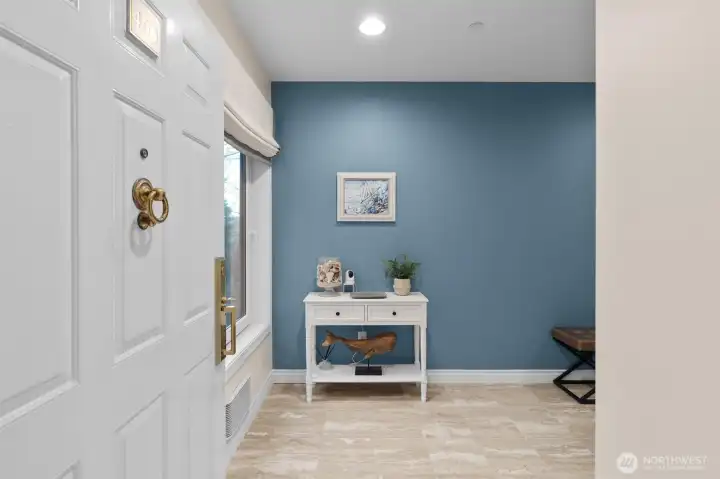 This end-unit condo has a welcoming entry with a gleaming stone floor.