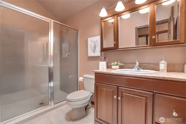 Hall bath serving the three upstairs bedrooms, with full-size shower, generous vanity storage, and room to easily freshen finishes down the road if desired.