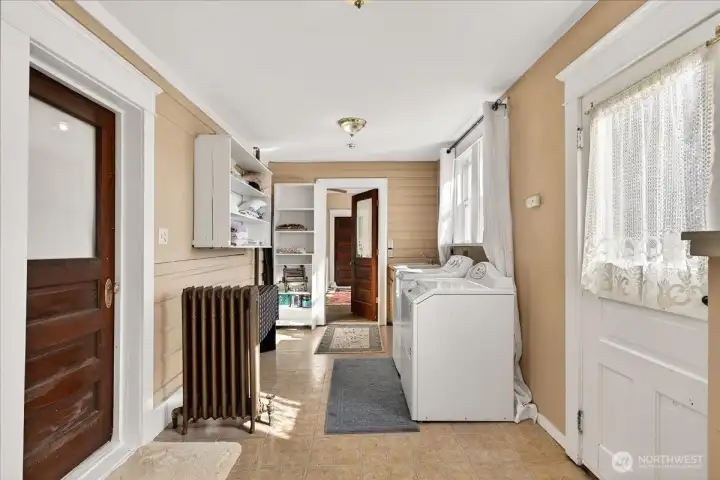 This spacious mudroom is a total must-have. There’s plenty of room for your washer and dryer, plus built-in shelving to keep everything organized as you come in from outside. It’s a practical, hardworking space that still keeps its vintage character with those solid wood doors and the original radiator.