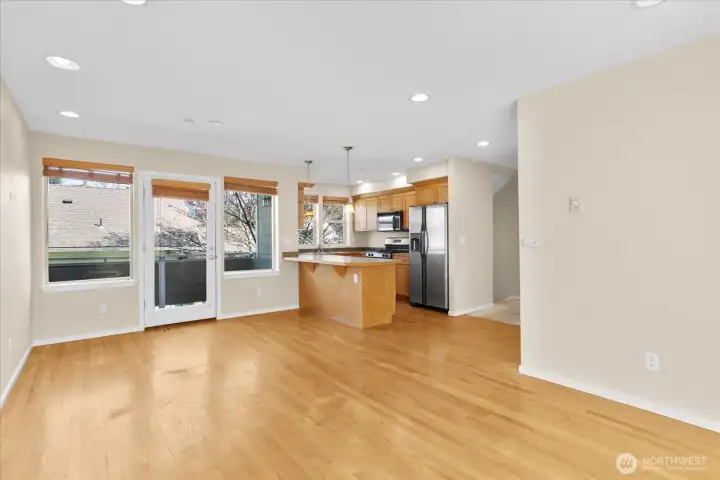 Kitchen with wood cabinetry, stainless steel appliances, pendant lighting, and access to a balcony through a glass door.