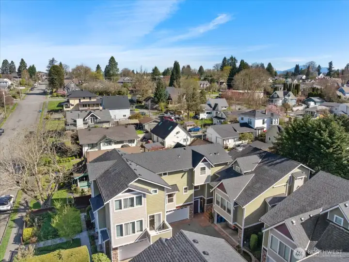 Aerial view of residential neighborhood showing multi-story homes, surrounding streets, and nearby houses.