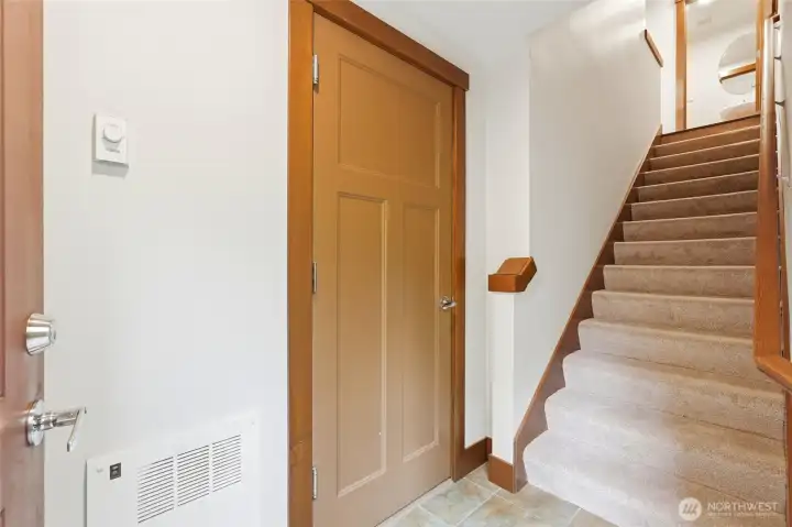 Entrer to stairwell leading to main level living area, with access to 1-car garage