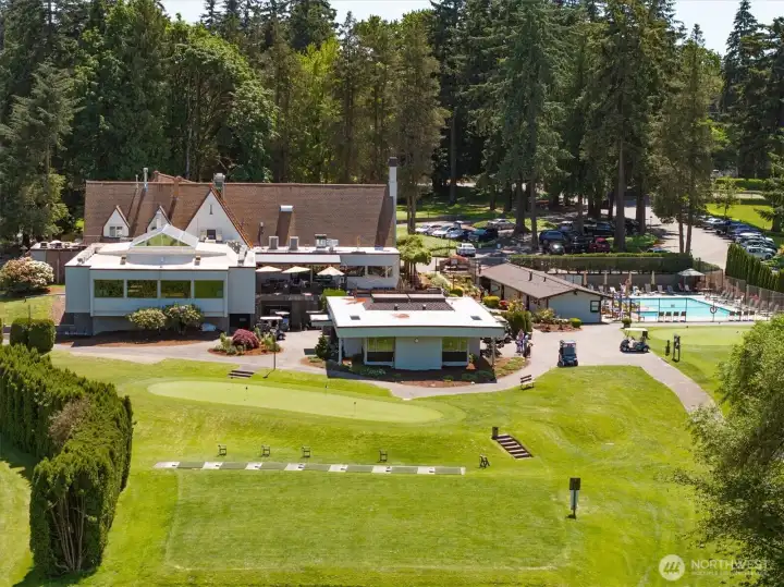 Drone view of the backside of the clubhouse, pool, pro shop, and putting green.