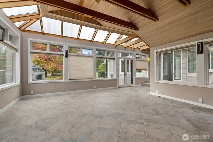 Atrium with exit onto terrace and outdoor fireplace.