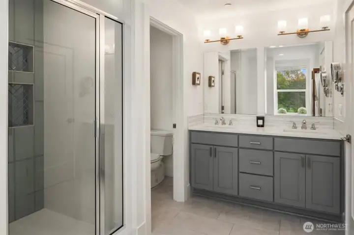 His and hers primary bathroom with quartz counter tops and walk in spa shower as well as a walk in closet. His and hers primary bathroom with quartz counter tops and walk in spa shower as well as a walk in closet.