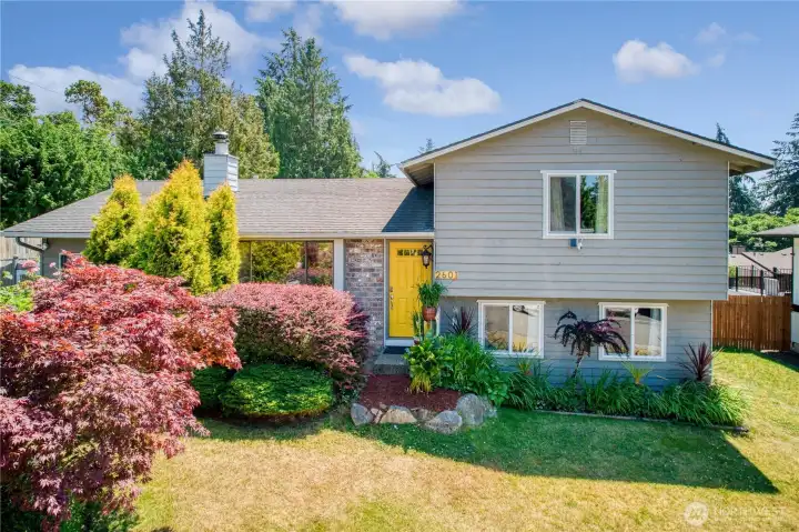 Welcome to 2601 — where charming curb appeal meets a cheerful yellow door and beautifully landscaped grounds bursting with color.