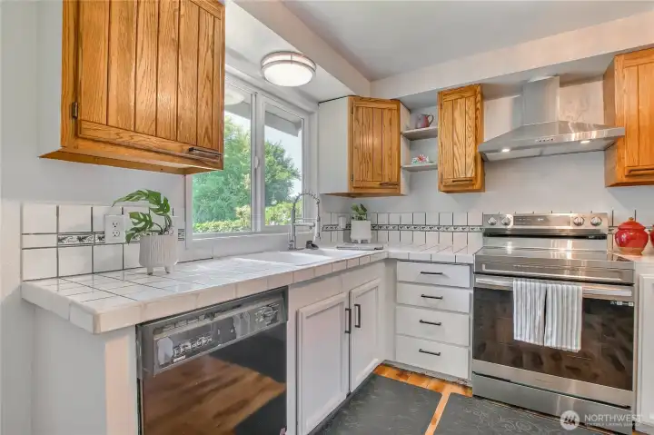 Crisp white and wood cabinetry with tiled counters and backsplash.