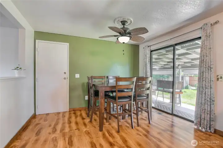 Welcoming eating space with laminate hardwood floors and patio access.