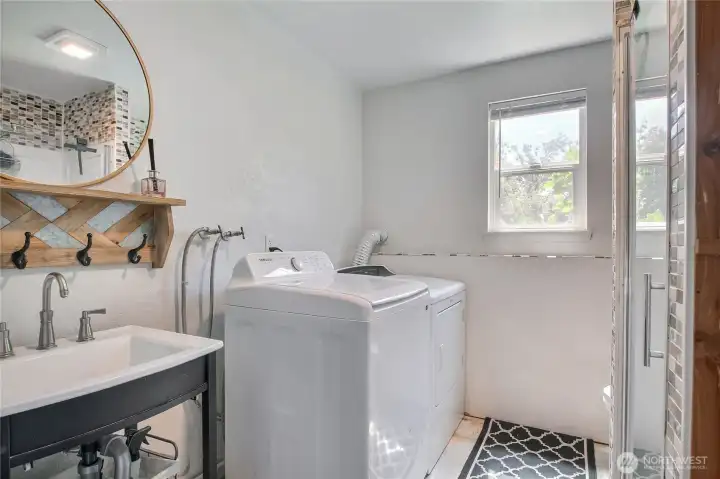 Lower-level 3/4 bath with attached laundry area and walk-in shower.