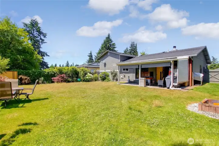 Covered patio flows into a spacious backyard, ideal for outdoor living.