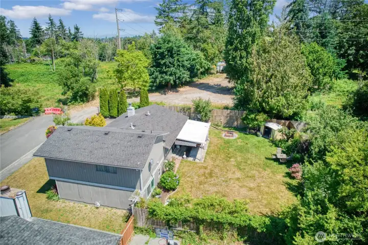 Expansive, fully fenced backyard with mature trees for privacy.