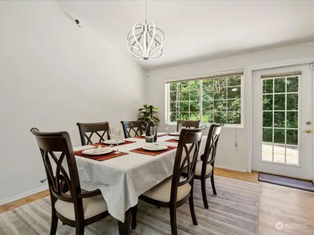 Dining room with a designer light fixture and door to the expansive deck for summer entertaining.