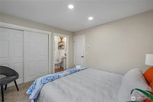 Another view of the primary bedroom with large closet and bathroom with walk in shower.