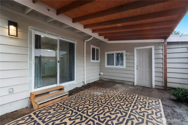 Covered outdoor area outside of the 3rd bedroom, and leading into the single car garage.