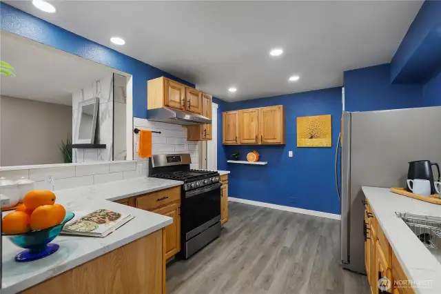 Spacious kitchen with quartz countertops and modern blue walls.