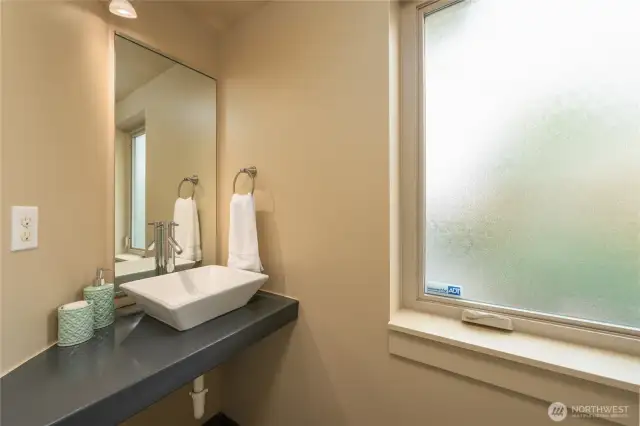 Bottom floor half bath with a big frosted window that opens.