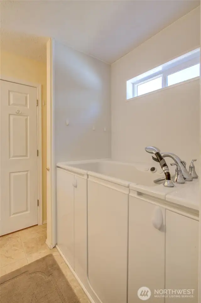 Primary bath also features walk in jetted tub with shower hose.