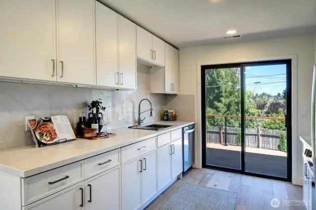 Spacious kitchen opens to the deck overlooking the backyard for easy access when grilling and entertaining.