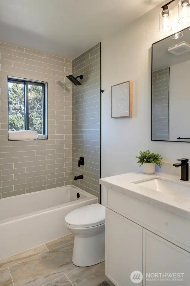 Main floor full bath boasts custom tiles and stylish fixtures.