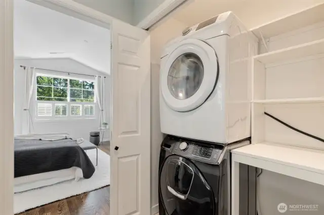 stacked laundry and folding area between primary and 2nd/3rd bedrooms