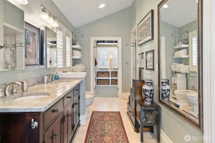 Gorgeous Primary bathroom with marble counter-tops and travertine flooring. Leading into spacious walk-in closet.