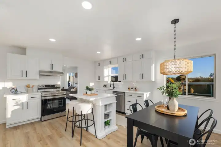 Open-concept kitchen and dining area with center island seating, coordinated lighting, and seamless connection to the main living space.