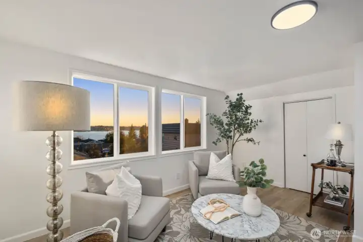 Alternate angle of the upstairs sitting area highlighting the expansive windows and open feel with water and treetop outlooks.