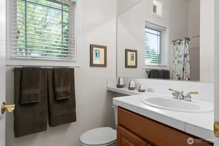 Guest en-suite full bath is appointed with opening window for light and added ventilation.