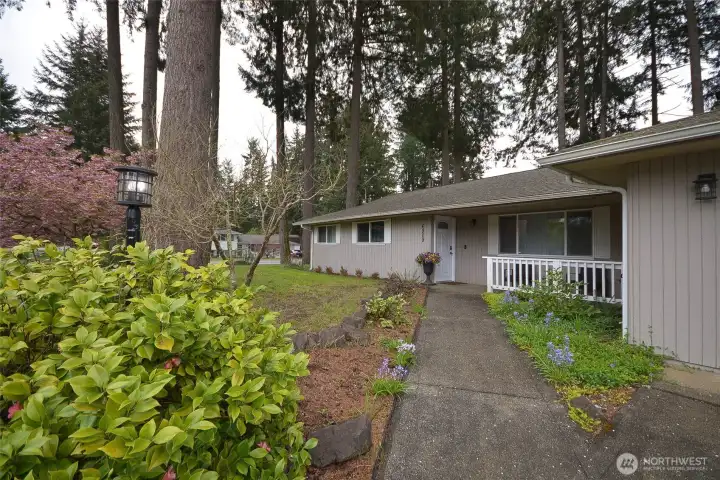 A spacious driveway leads to the two-car garage, complemented by concrete walkways that guide you to the inviting covered front porch.