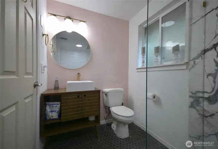 This remodled bathroom is off the formal dining room / Den area has beautiful vanity with glass door leading to the fully tiled floor and full surround marble tile, stand alone floating tub and stand alone rain shower.