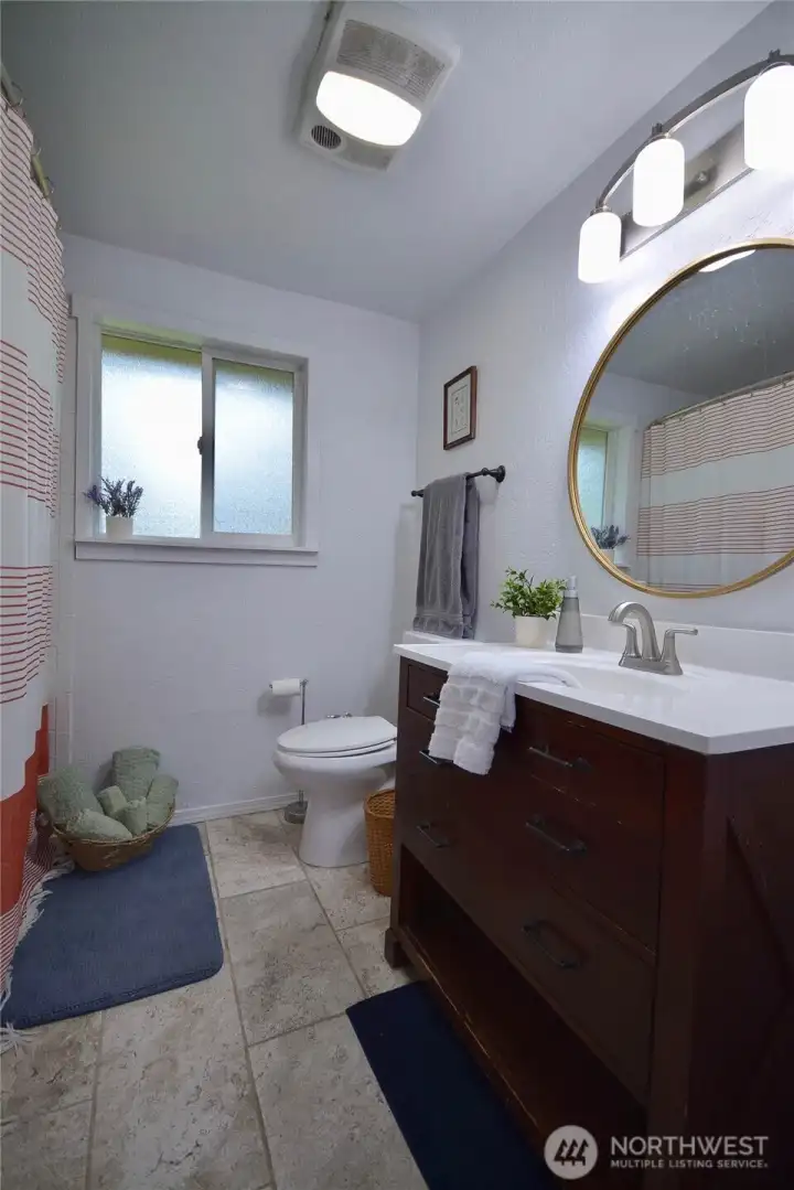 Guest bathroom offers full tub with shower large vanity and closet with shelves.