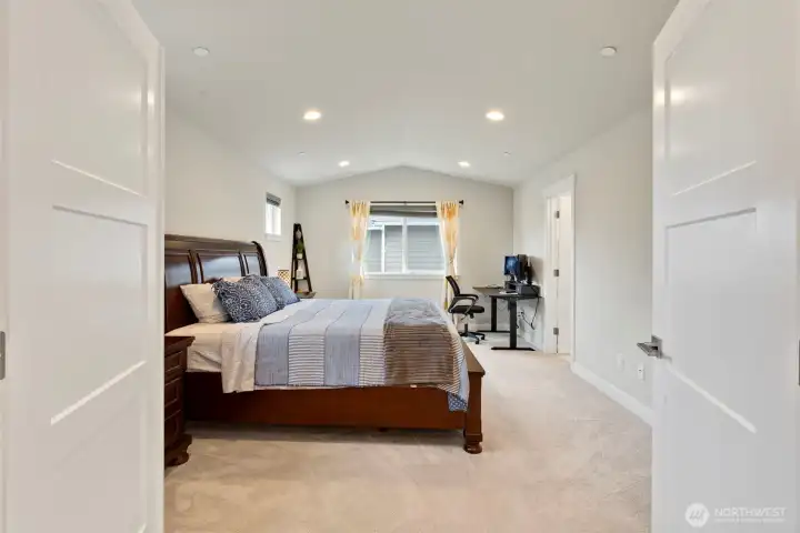 Double doors lead to the large vaulted primary suite.