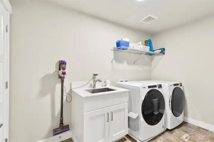 Large laundry room with cabinet and sink.  The washer & dryer stay.