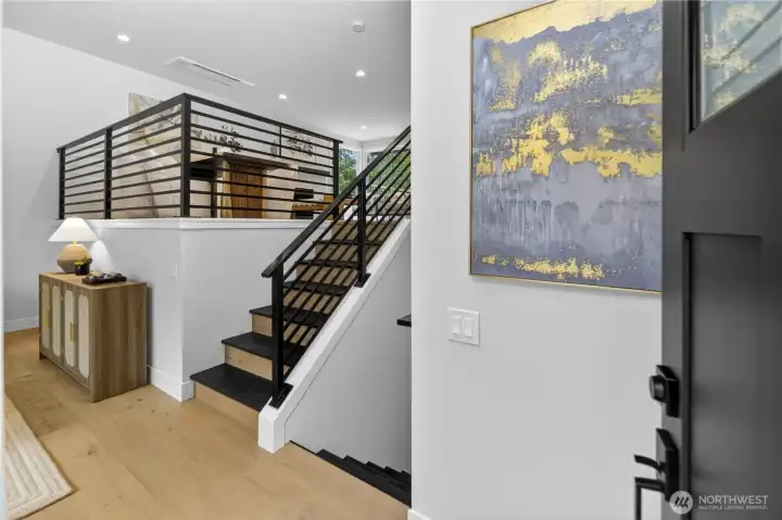 High ceilings, crisp white paint, modern linear railings, and luxury engineered hardwood floors create a fresh, uplifting welcome as you step inside. Warm natural-light bulbs in the recessed lighting give the home a soft, even glow. New black interior trim details carry the Pacific Northwest-inspired exterior design inside, creating a cohesive modern look from the entry onward. High ceilings, crisp white paint, modern linear railings, and luxury engineered hardwood floors create a fresh, uplifting welcome as you step inside. Warm natural-light bulbs in the recessed lighting give the home a soft, even glow. New black interior trim details carry the Pacific Northwest-inspired exterior design inside, creating a cohesive modern look from the entry onward.