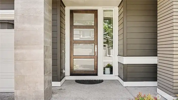 Inviting covered porch featuring a modern front door. Inviting covered porch featuring a modern front door.