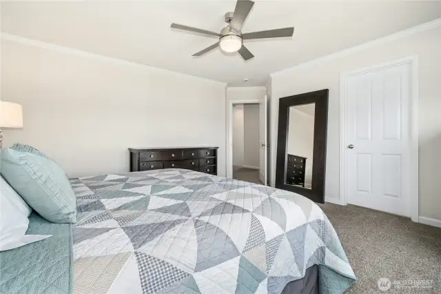 Primary suite bedroom with ceiling fan.