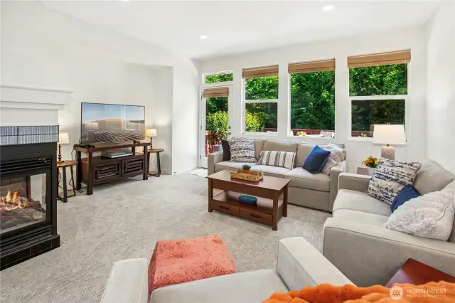 The greatroom features a gas tile fireplace, media nook and showcases the serene greenbelt.