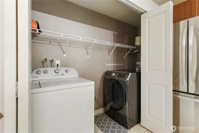 Utility closet featuring new hot water tank and dryer