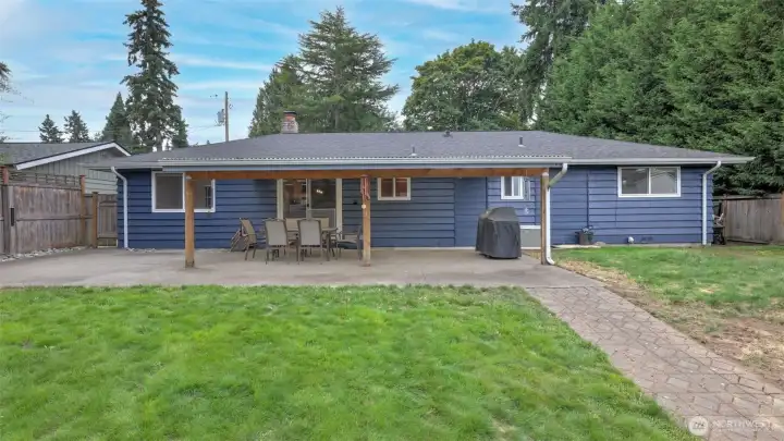 Spacious backyard with a covered patio, perfect for outdoor dining, barbecues, and year-round enjoyment.