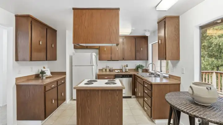 Island cooktop and generous counter space make this kitchen as practical as it is inviting.
