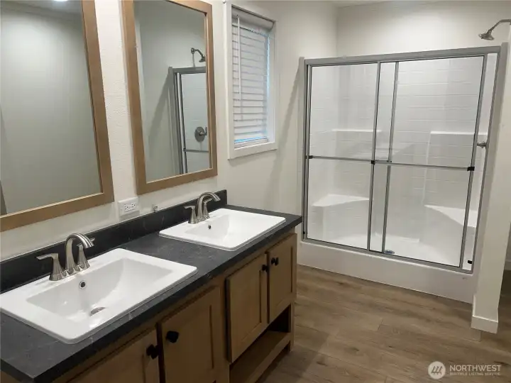 Primary bathroom with double vanity and walk in shower.