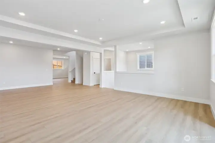 Great room looking toward entry hall and main floor powder room. Photo is of similar home-details & finishes will vary-ask site agent for details
