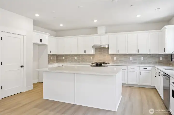 Kitchen features GE Cafe gas range, dishwasher and microwave, as well as a desirable pantry for additional storage. Photo is of similar home-details & finishes will vary-ask site agent for details