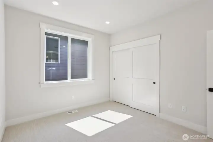 Secondary bedroom at the top of the stairs features double door entry and can easily function as an open loft area.  Photo is of similar home-details & finishes will vary-ask site agent for details