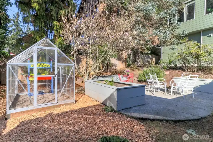 Firepit area, green house and raised flower beds