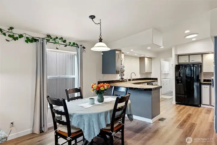 Just beyond the first living space is a lovely dining area, connected to the spacious kitchen. The open layout creates a great flow for entertaining and everyday living, making it perfect for family gatherings and casual meals.
