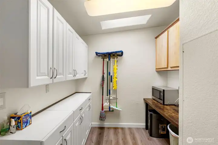 From the kitchen, you'll find a super roomy storage area – perfect for all your stuff! The water heater and new furnace are neatly tucked away, so it's both practical and keeps things tidy. Plus, it's got tons of cupboards and a good-sized workspace, making it super useful!