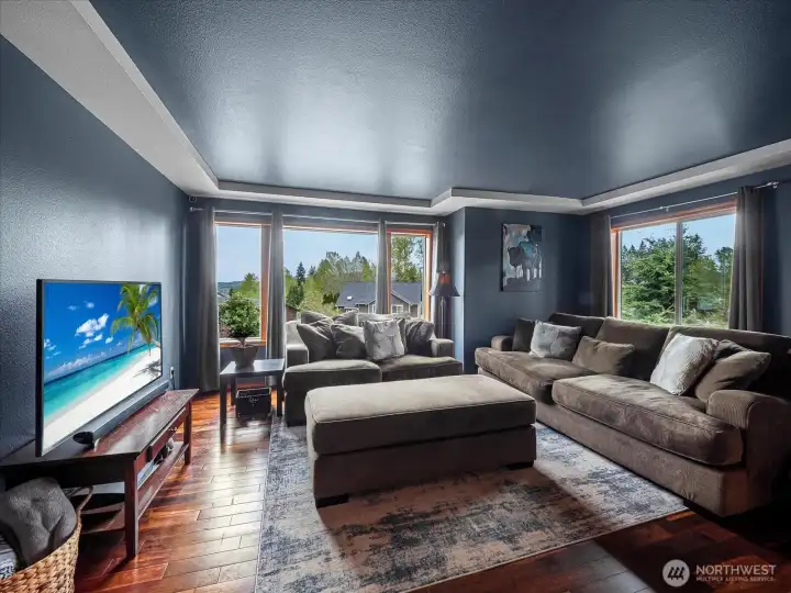 Hardwood floors, gas fireplace, and coffered ceiling in the living room.