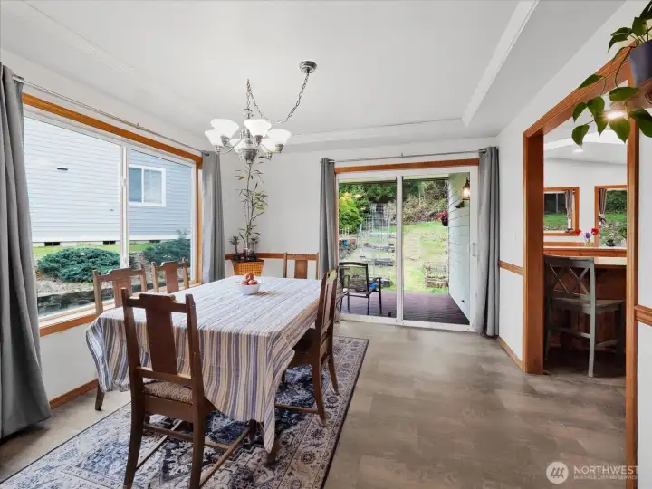 Dining room with large windows, coffered ceiling, and opens to covered back porch.